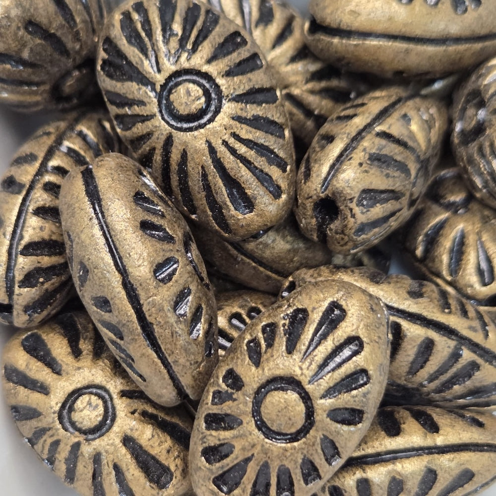 Close-up of bronze-colored metal beads with intricate patterns.