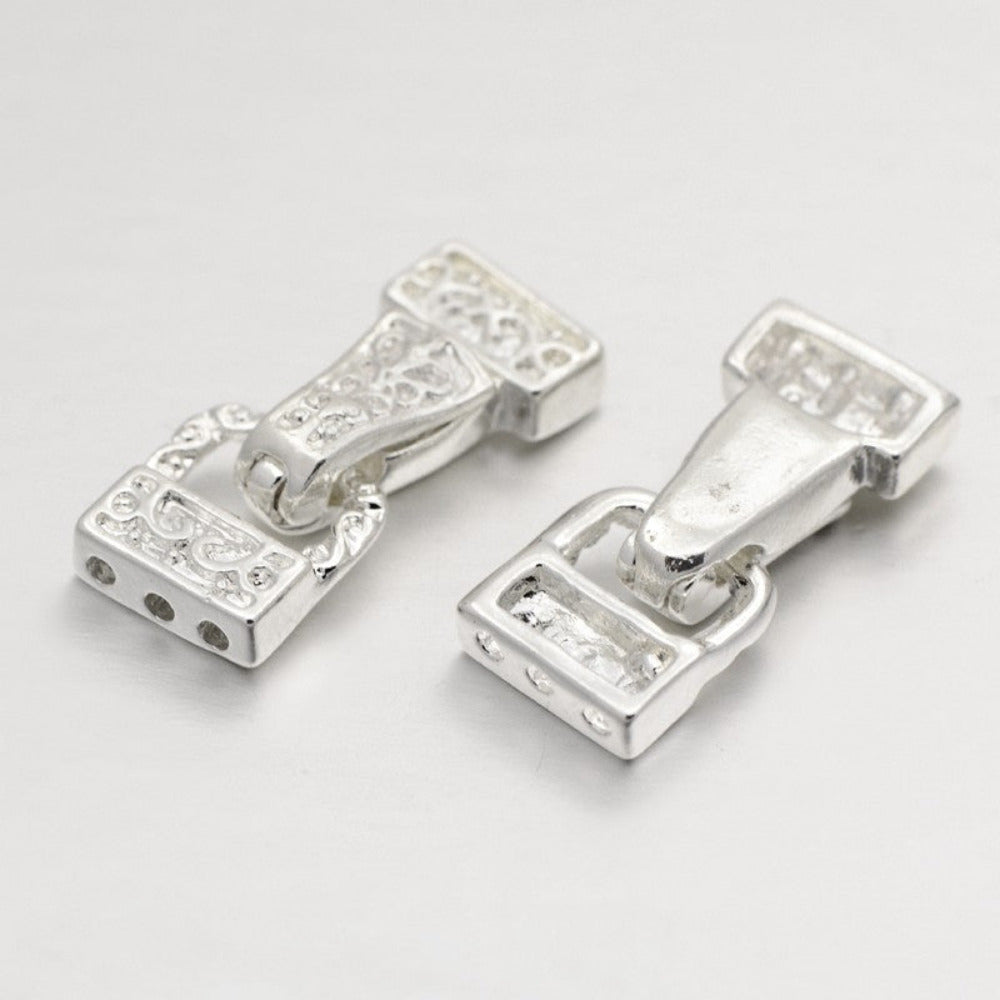 Pair of silver buckle-style clasps on a light gray background