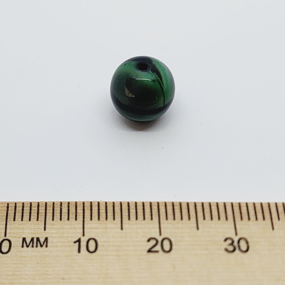 malachite green and black bead with a ruler to show scale