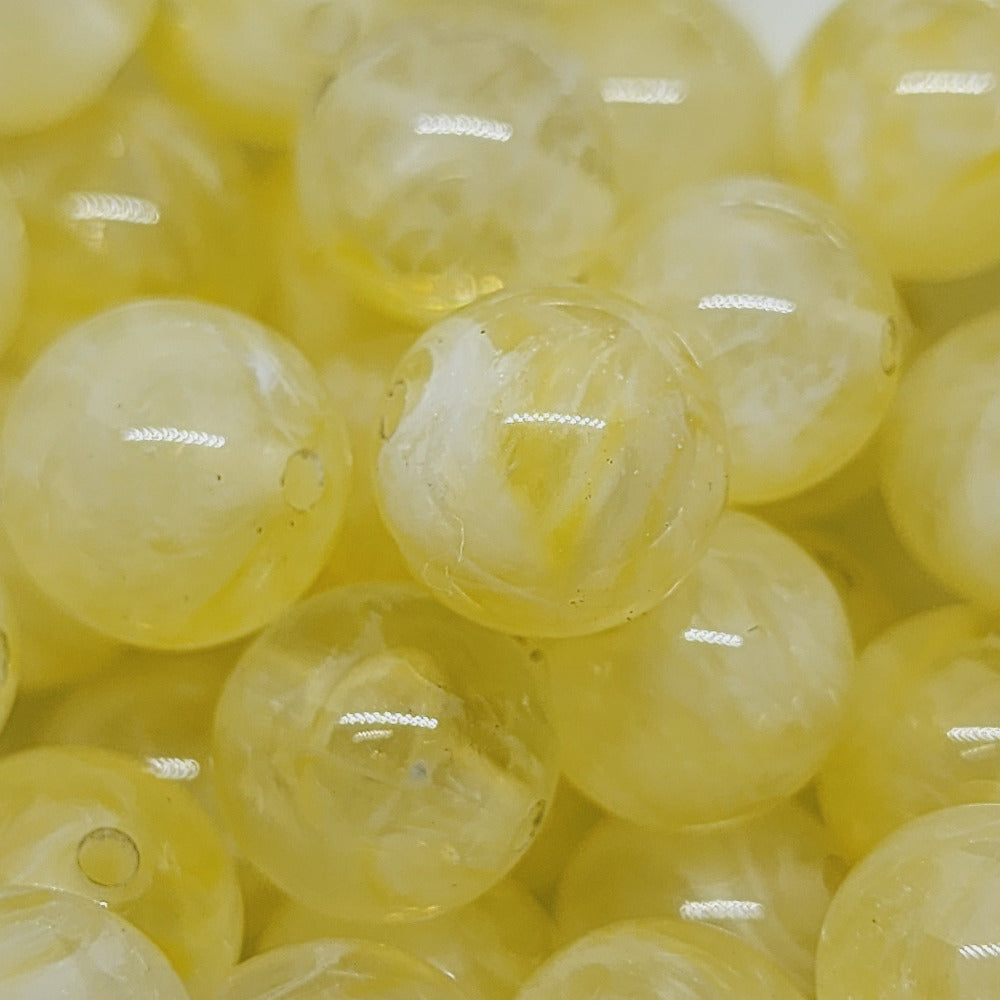 Citrine yellow gemstone style acrylic beads with visible threading holes for crafting jewelry on a white background