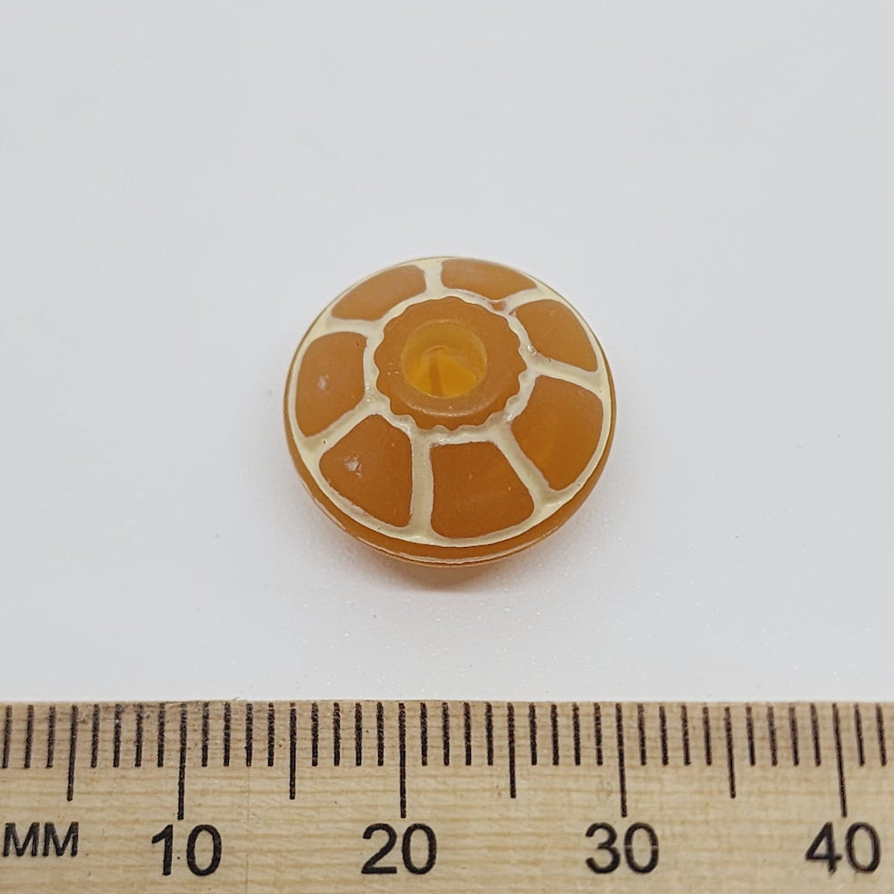 A collection of vintage orange and white lucite beads with a baroque pattern, reminiscent of a turtle's shell, used for crafting jewelry such as necklaces and bracelets next to a ruler for scale