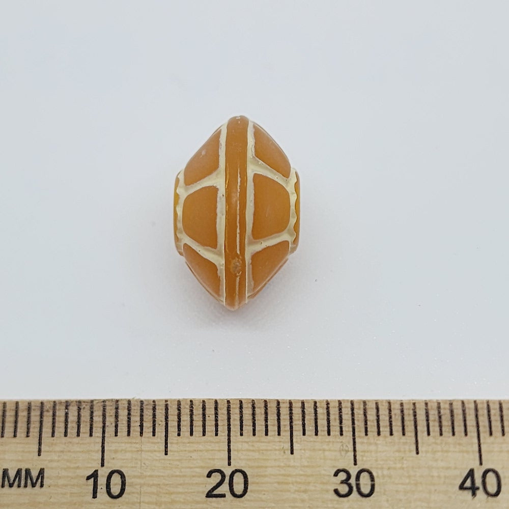 A collection of vintage orange and white lucite beads with a baroque pattern, reminiscent of a turtle's shell, used for crafting jewelry such as necklaces and bracelets next to a ruler for scale