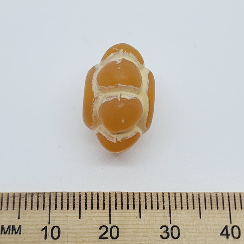baroque vintage transparent orange wheel pumpkin shape beads with intricate orange and white designs showing visible holes for threading jewelry and earrings on a ruler for scale