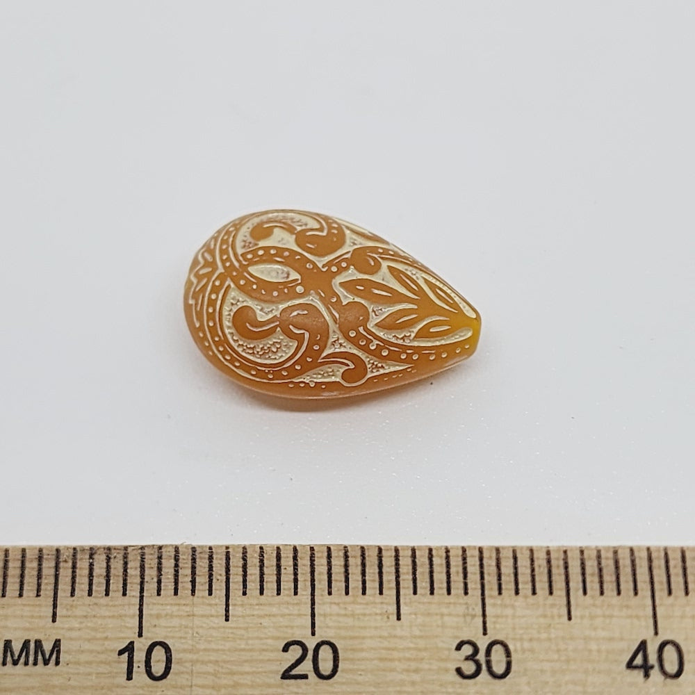 baroque vintage transparent orange drop beads with intricate orange and white designs showing visible holes for threading jewelry and earrings next to a ruler to show scale
