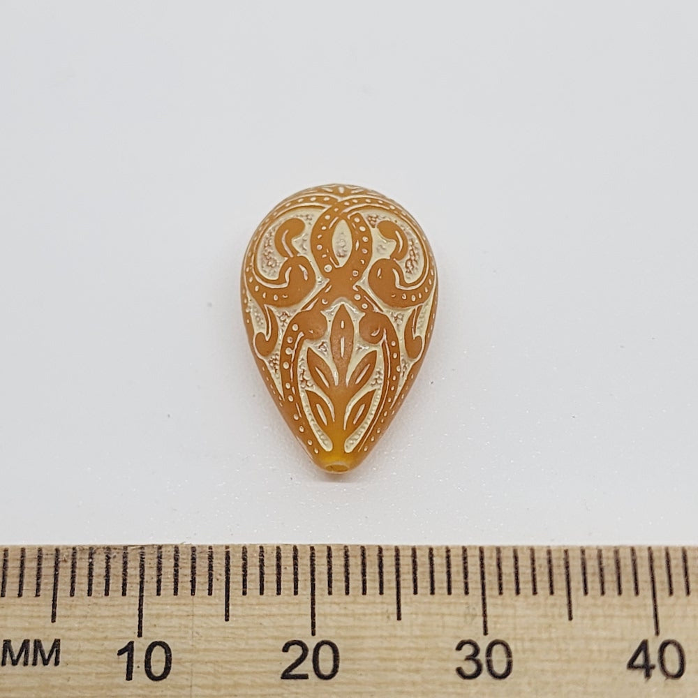 baroque vintage transparent orange drop beads with intricate orange and white designs showing visible holes for threading jewelry and earrings next to a ruler to show size