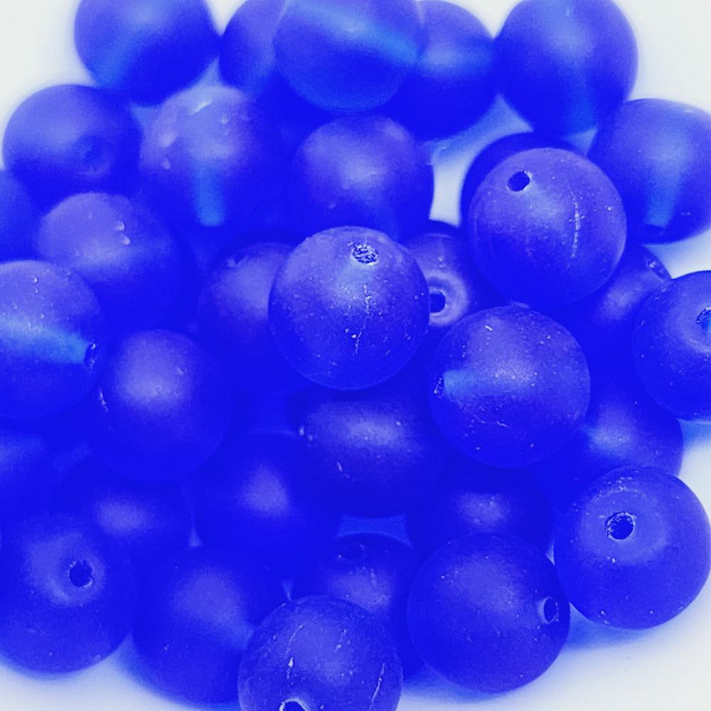 dark blue matte glass round beads showing threading holes to make jewelry