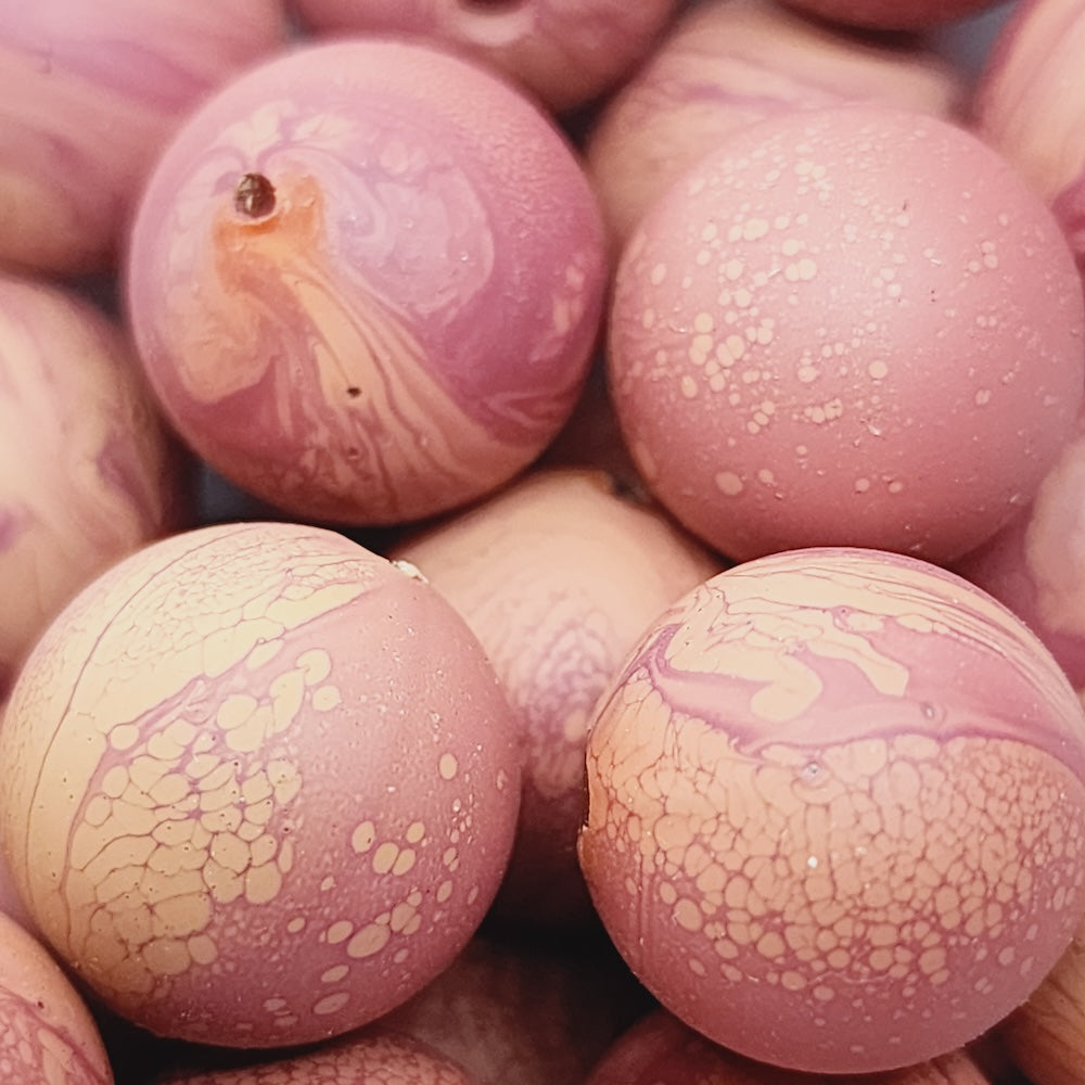 Close-up of marble finish wood look beads with a central hole.