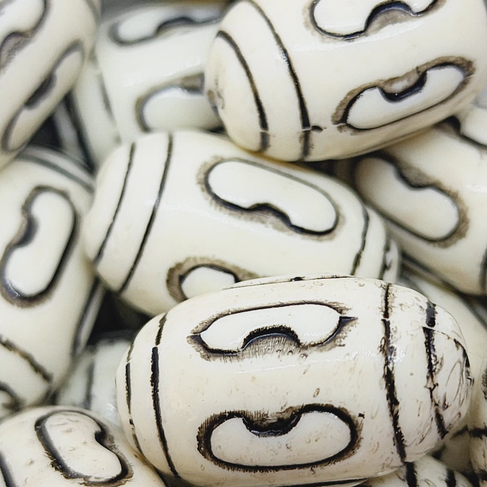 a group of vintage acrylic lucite beads with black etched designs, used to make jewelry and craft