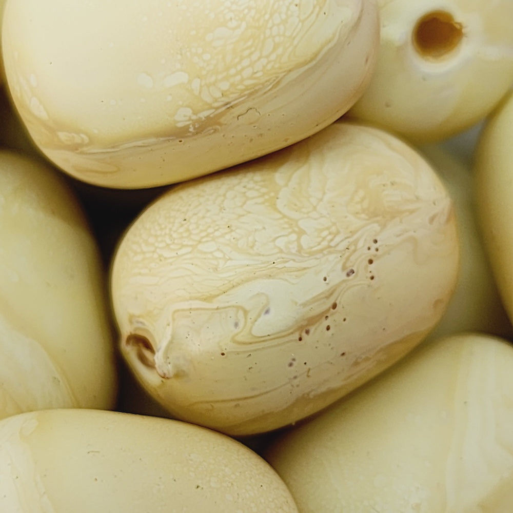 Close-up of beige wood look beads with a central hole.