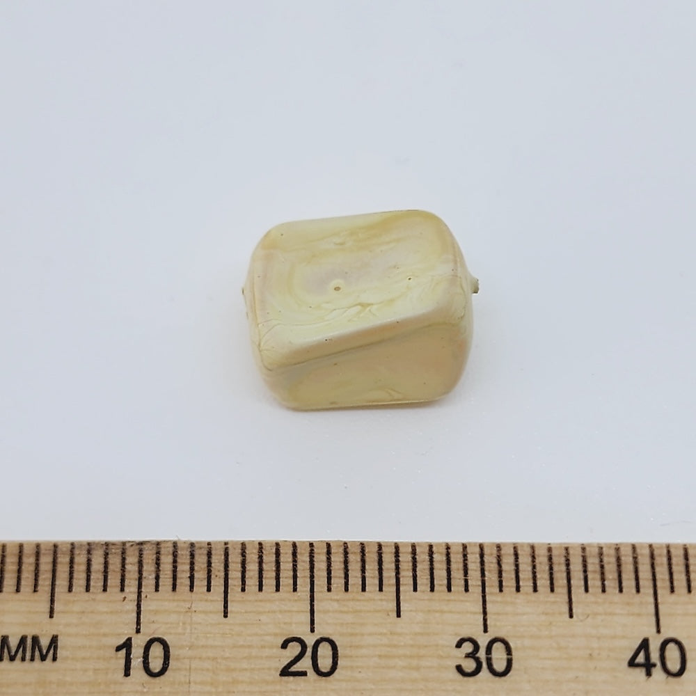 rectangular cream marble look bead on a white background with a ruler to show scale