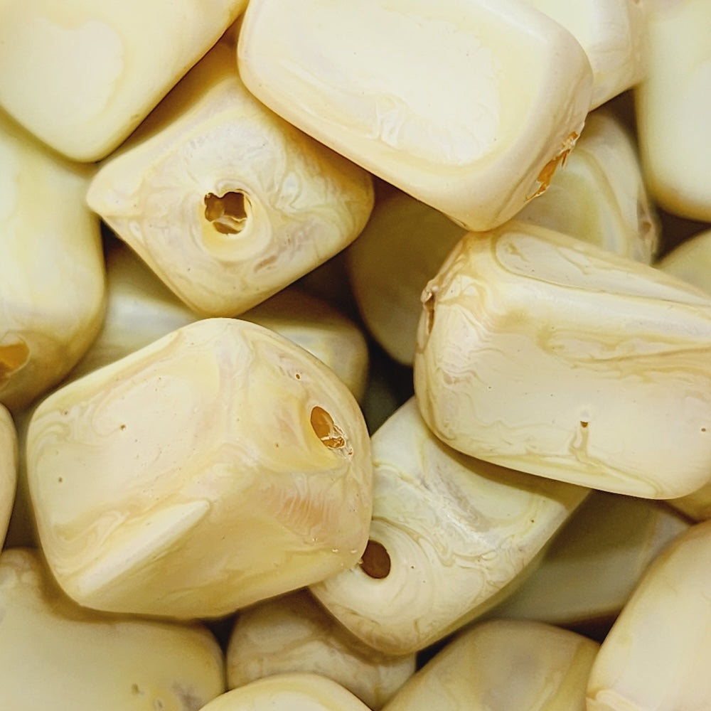 Close-up of marble finish wood look beads with a central hole.