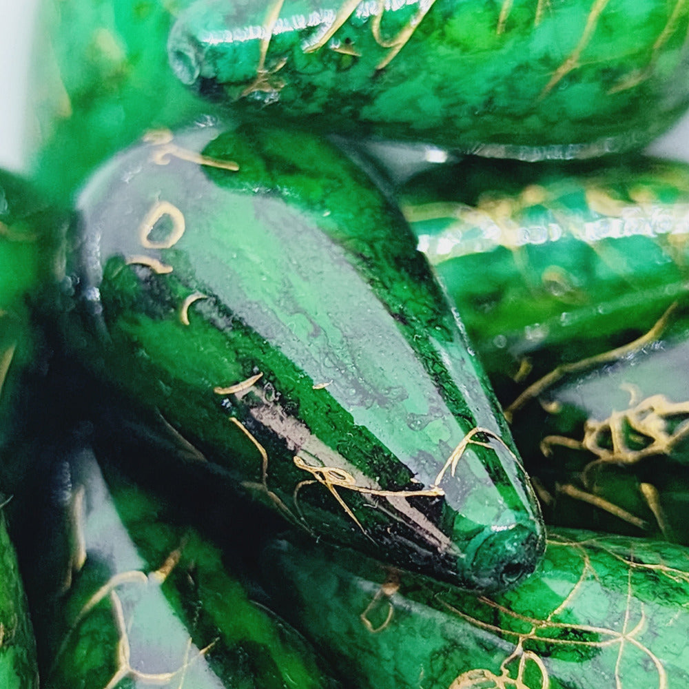 A group of teardrop-shaped vintage Lucite bead with a green bubble glaze look and gold drizzle patterns,