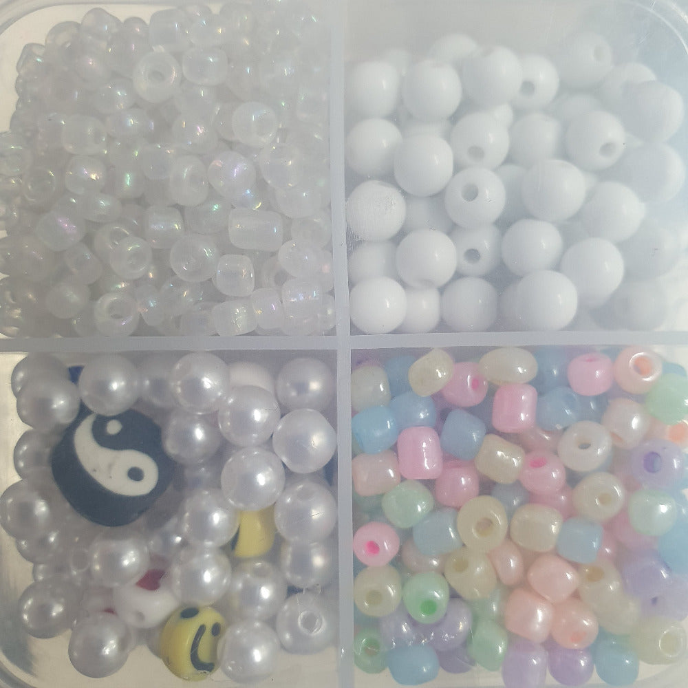 Small plastic compartment box holding colourful beads for the purpose of children making beaded projects and craft