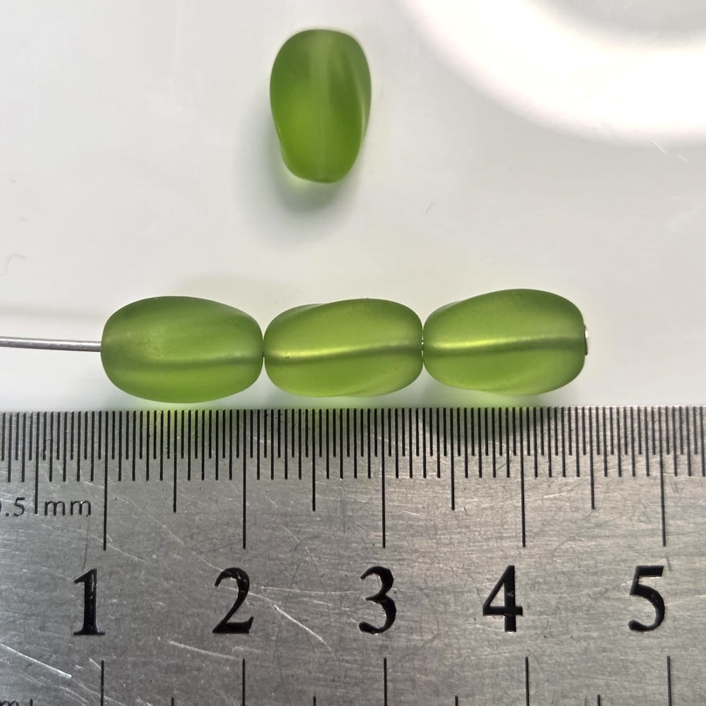 Green beads on a ruler for size reference