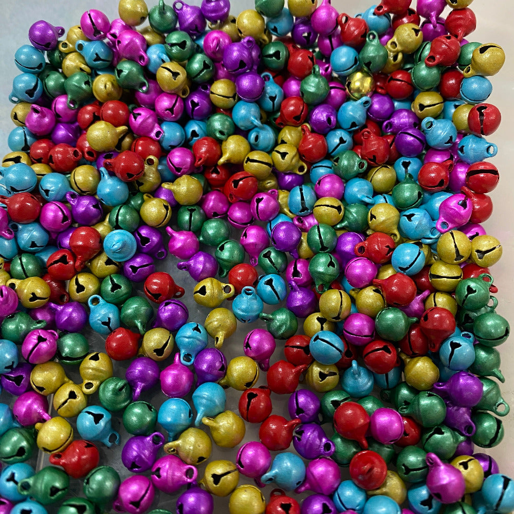 colourful metallic round bells on a white surface