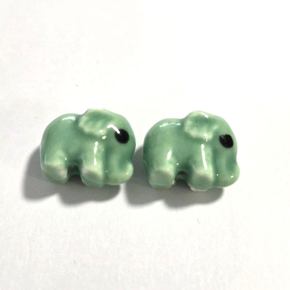 green ceramic elephant beads on a white surface