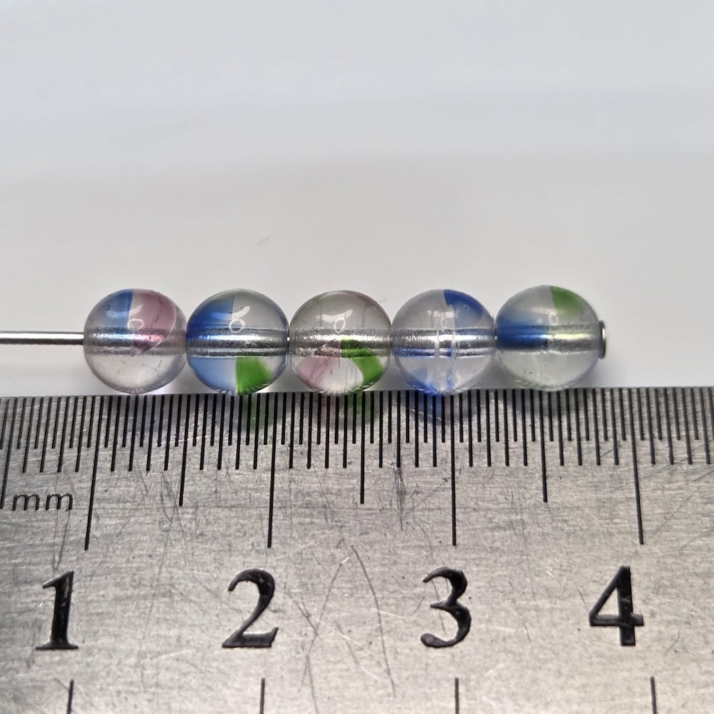 Colorful givre beads on a ruler for size reference