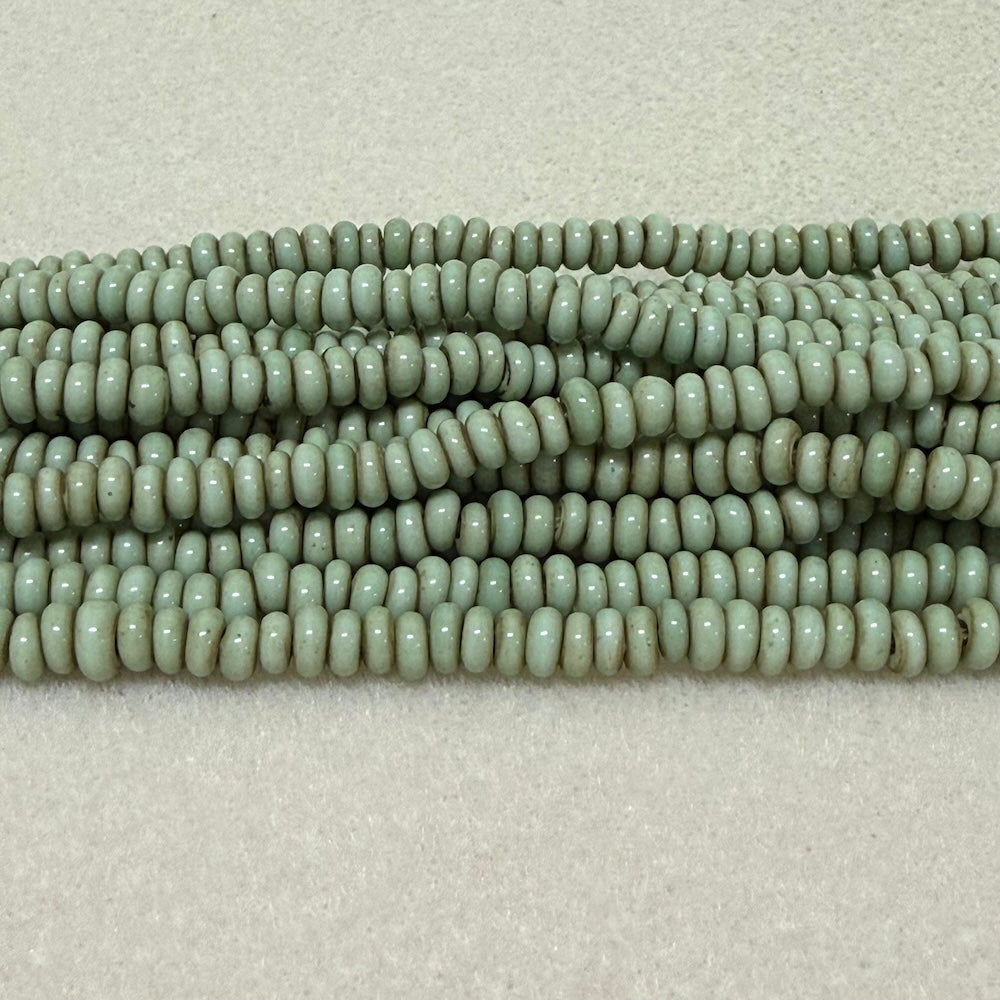 antique green mint donut shaped Indonesian glass bead strands on a white background