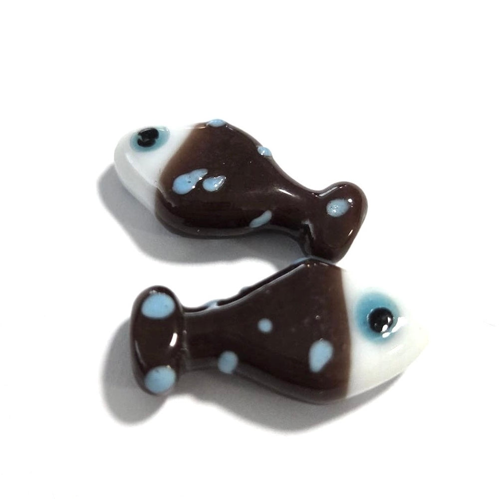Two brown fish-shaped objects with blue spots on a white background