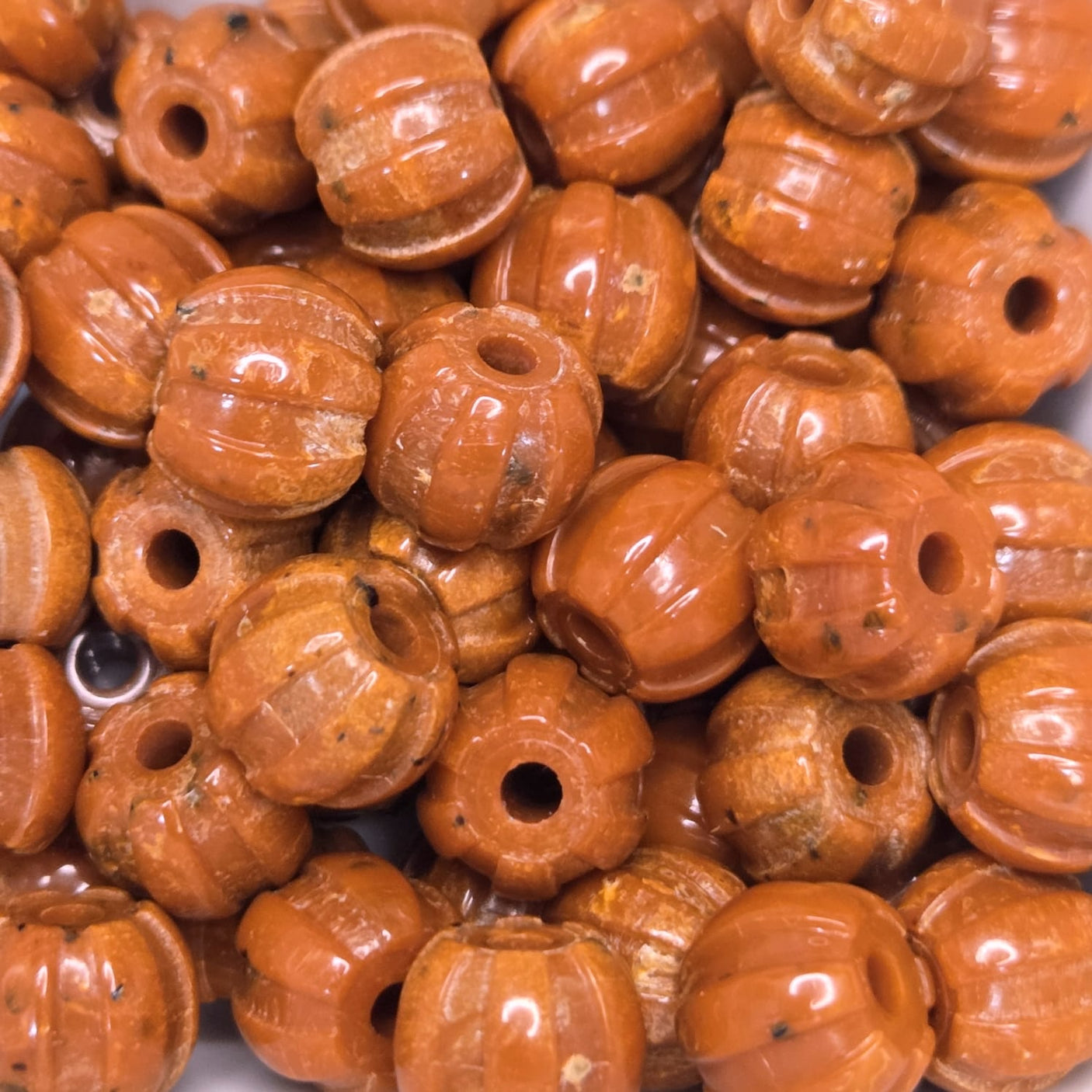 Close-up of orange pumpkin-shaped beads with a white background