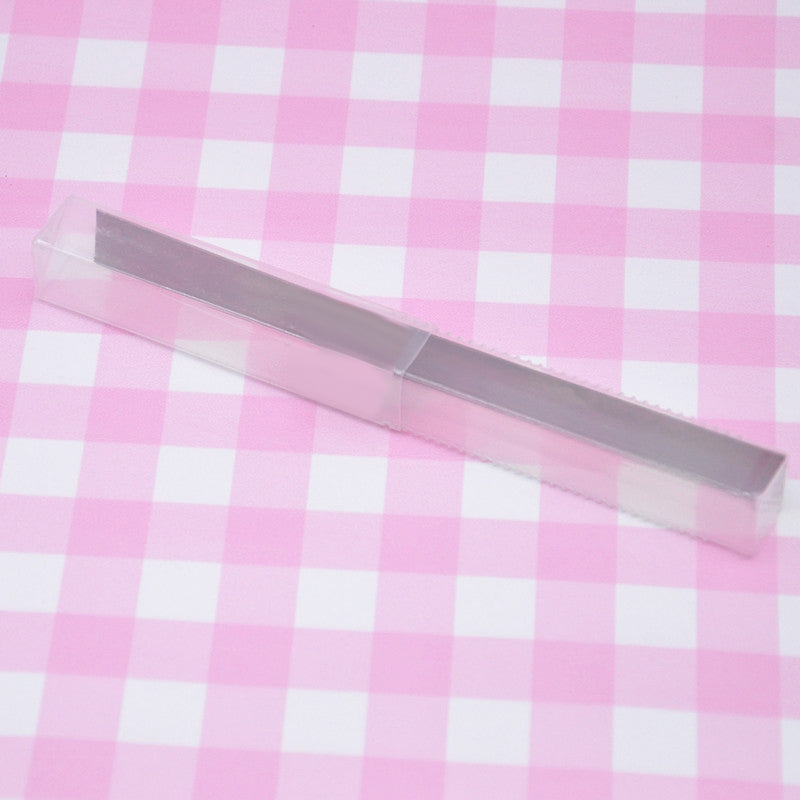 clay cutting blade with plastic container on a pink and white checked background