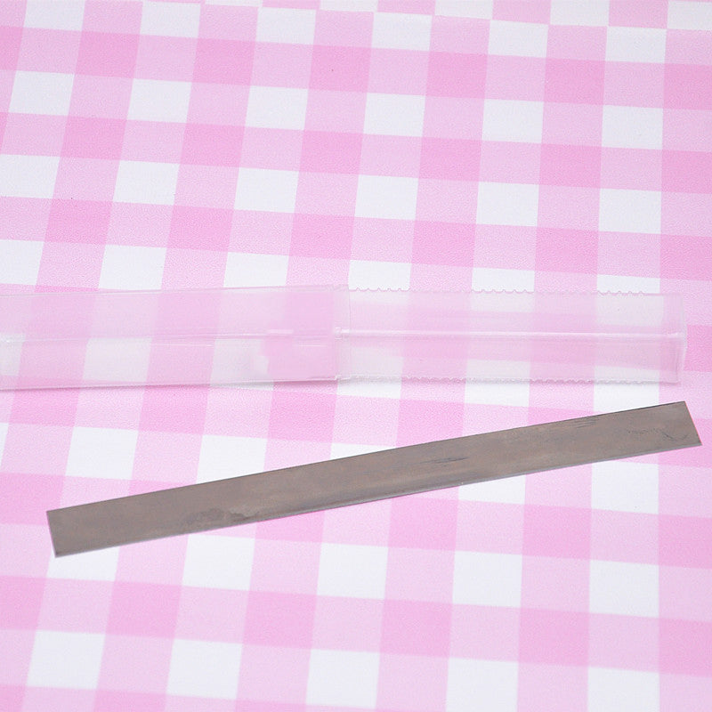 clay cutting blade with plastic container on a pink and white checked background
