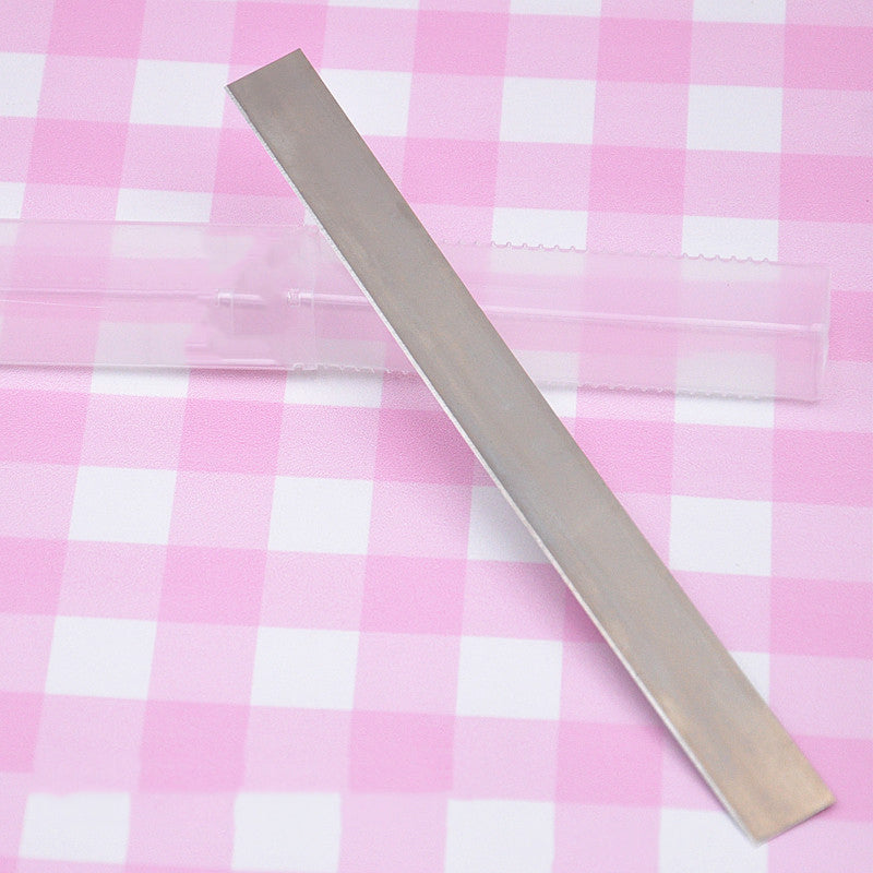 clay cutting blade with plastic container on a pink and white checked background