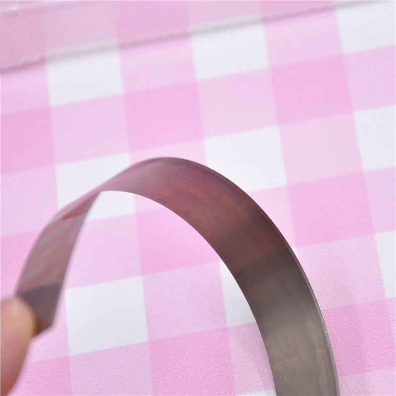 Clay cutting blade bent over with a pink checked background