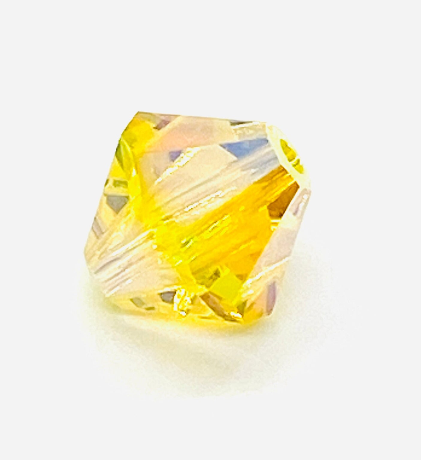 One yellow faceted crystal beads on a white background