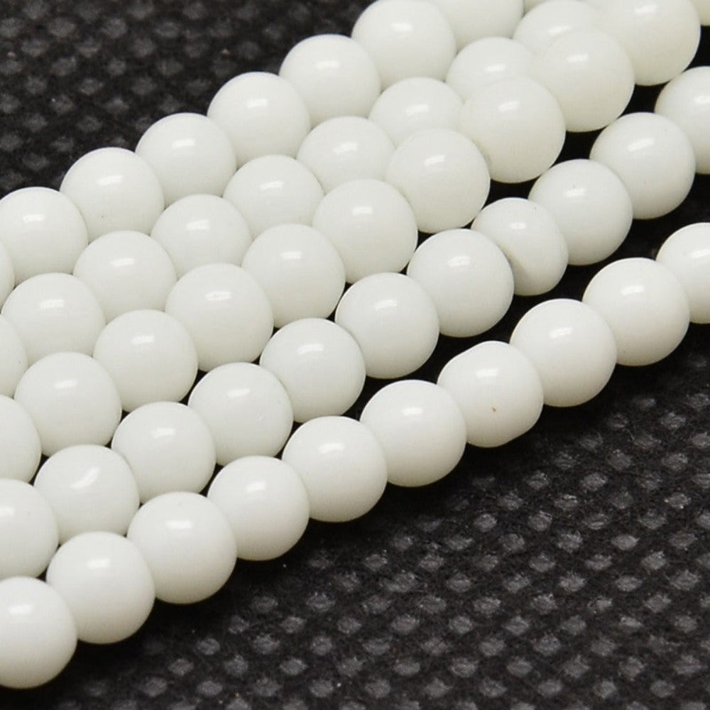 Close-up of white glass beads on a textured black surface