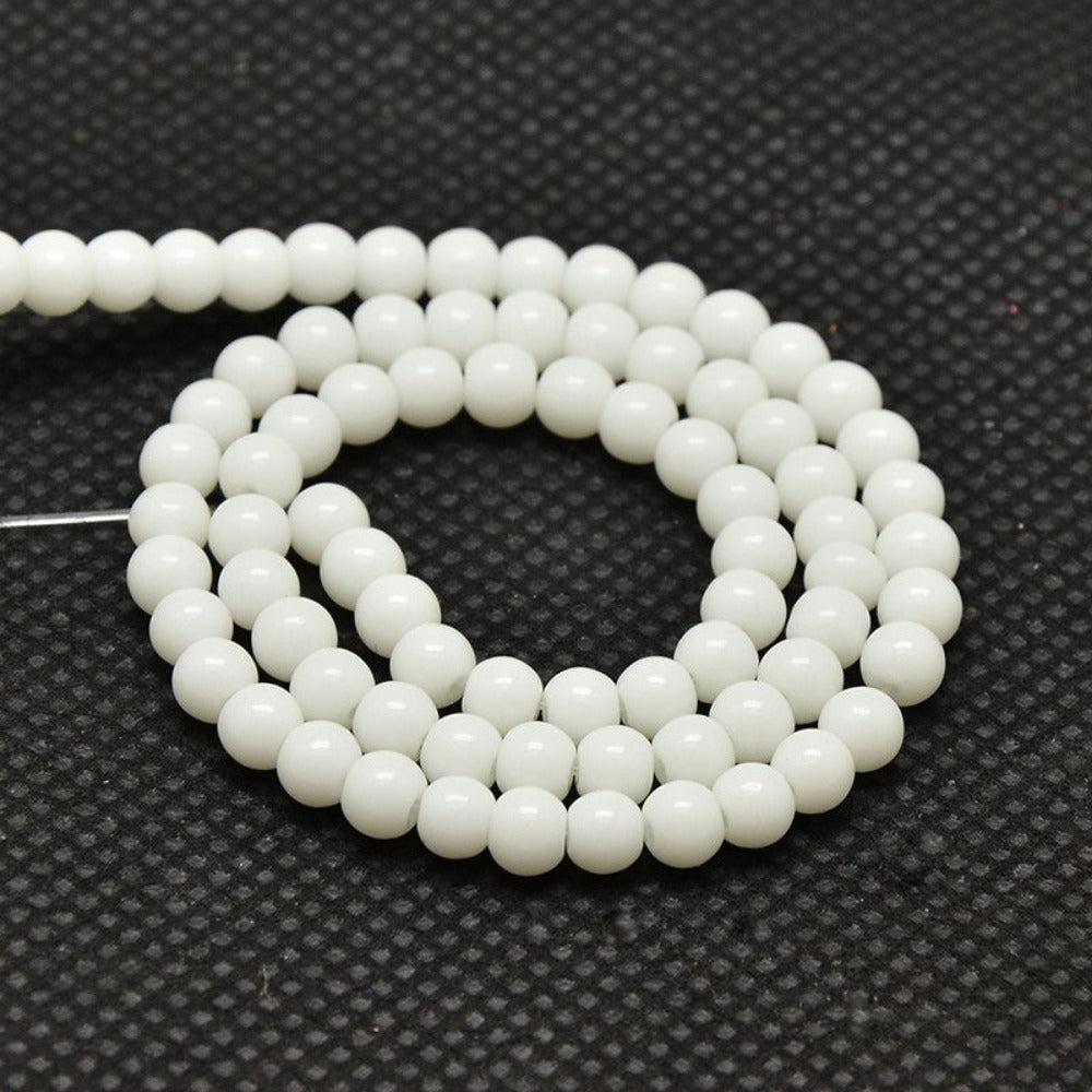 White round beads on a black textured background