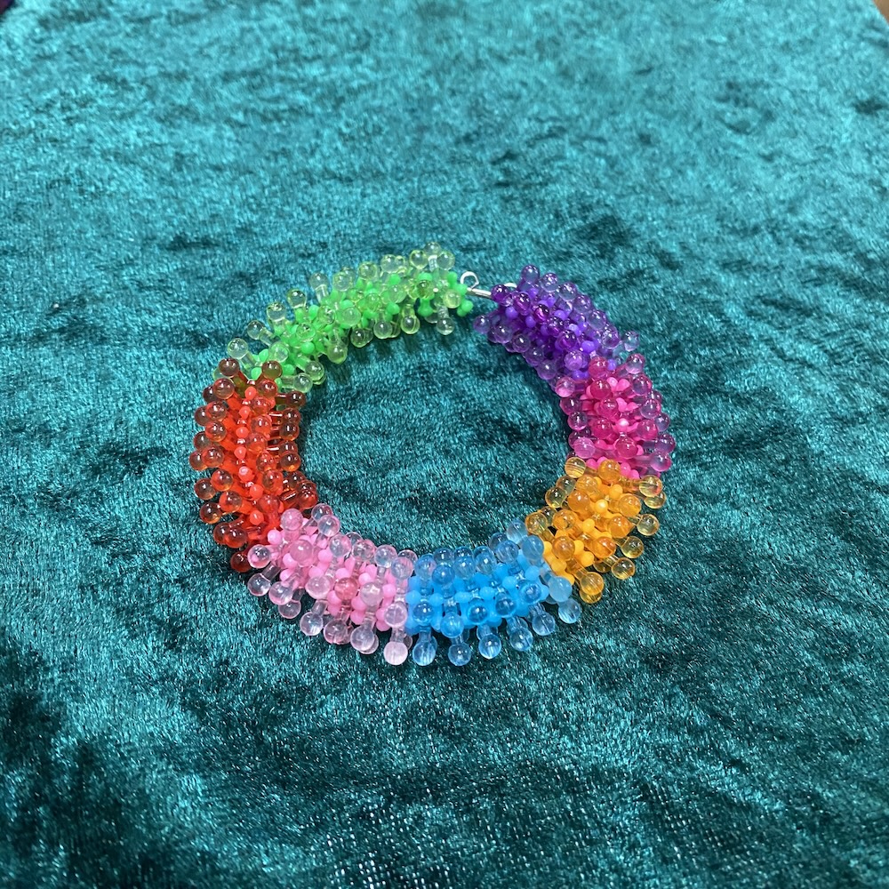 Colorful beaded bracelet on a textured teal background