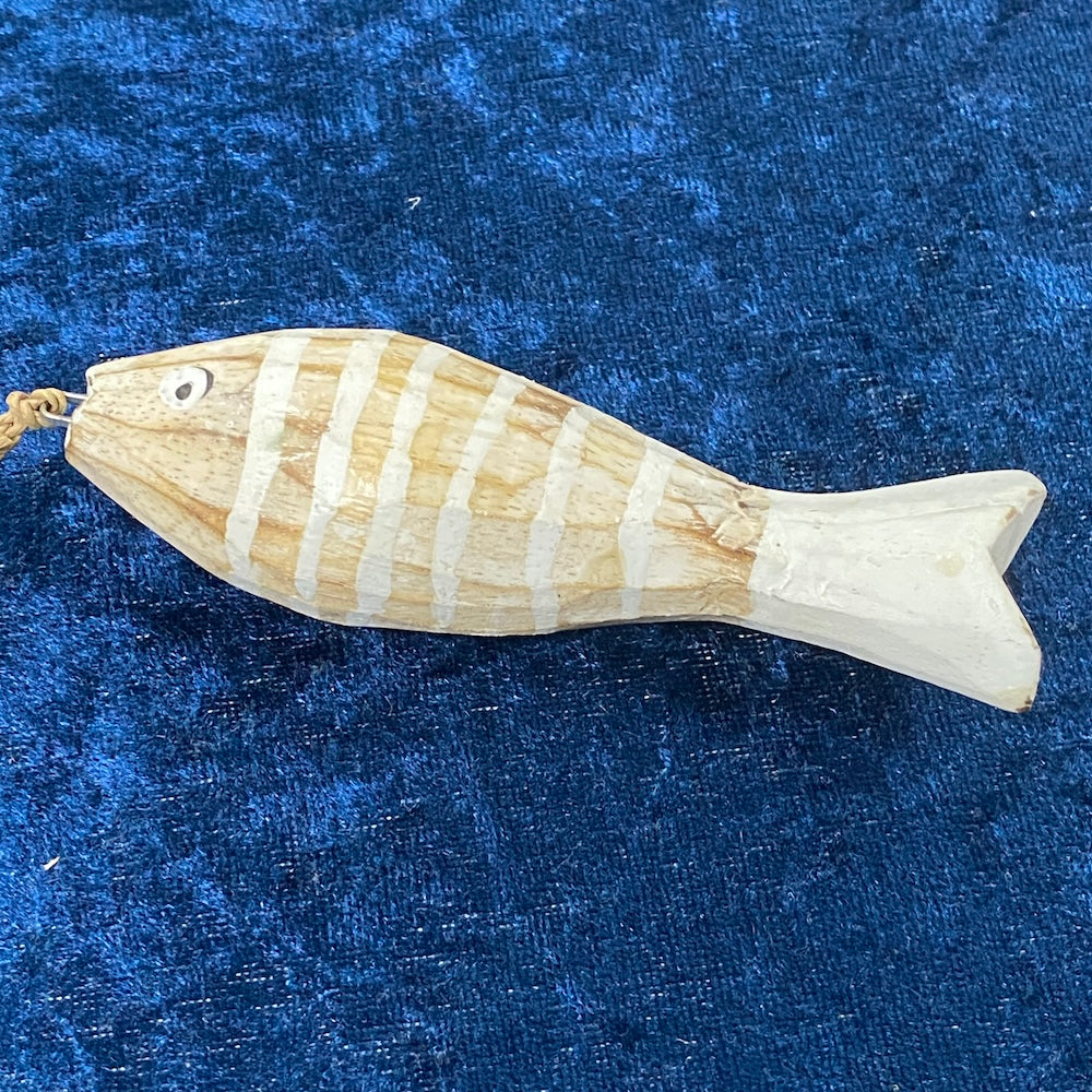 Wooden fish-shaped ornament on a blue textured background
