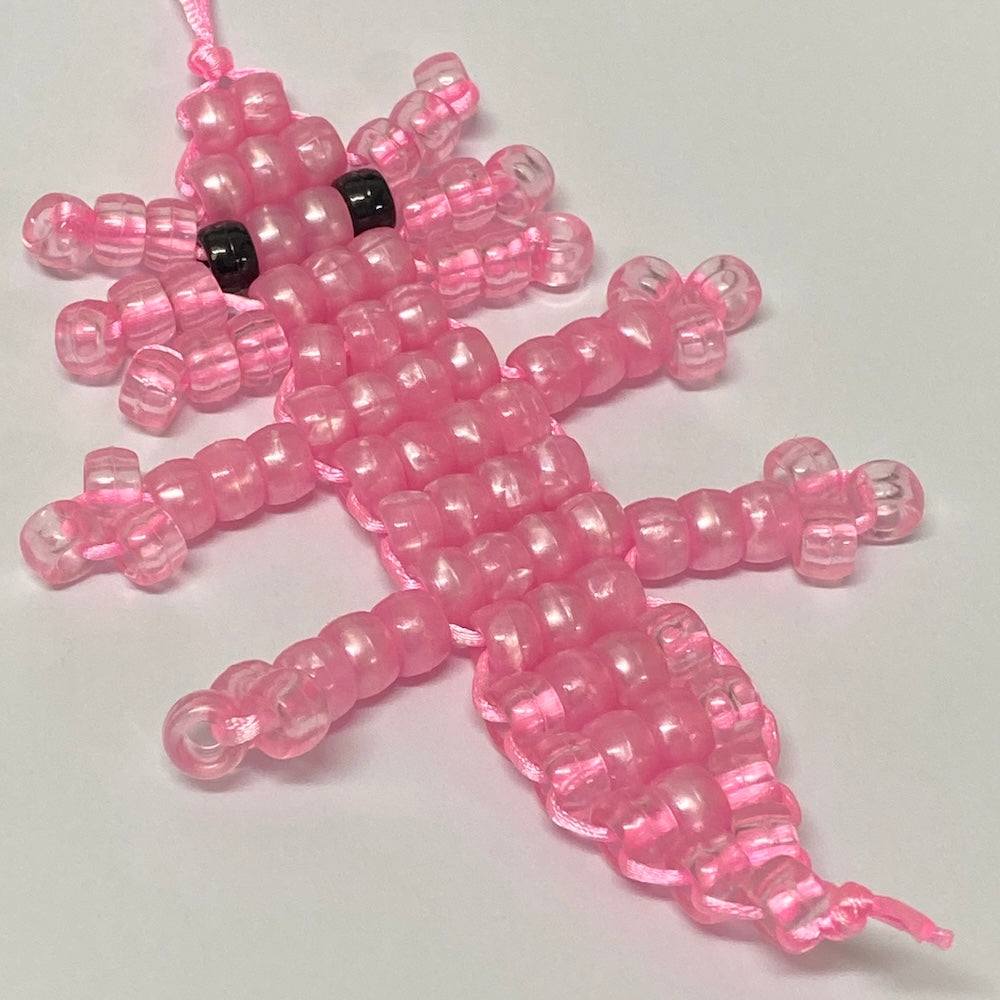 pink beaded axolotl toy on a white background