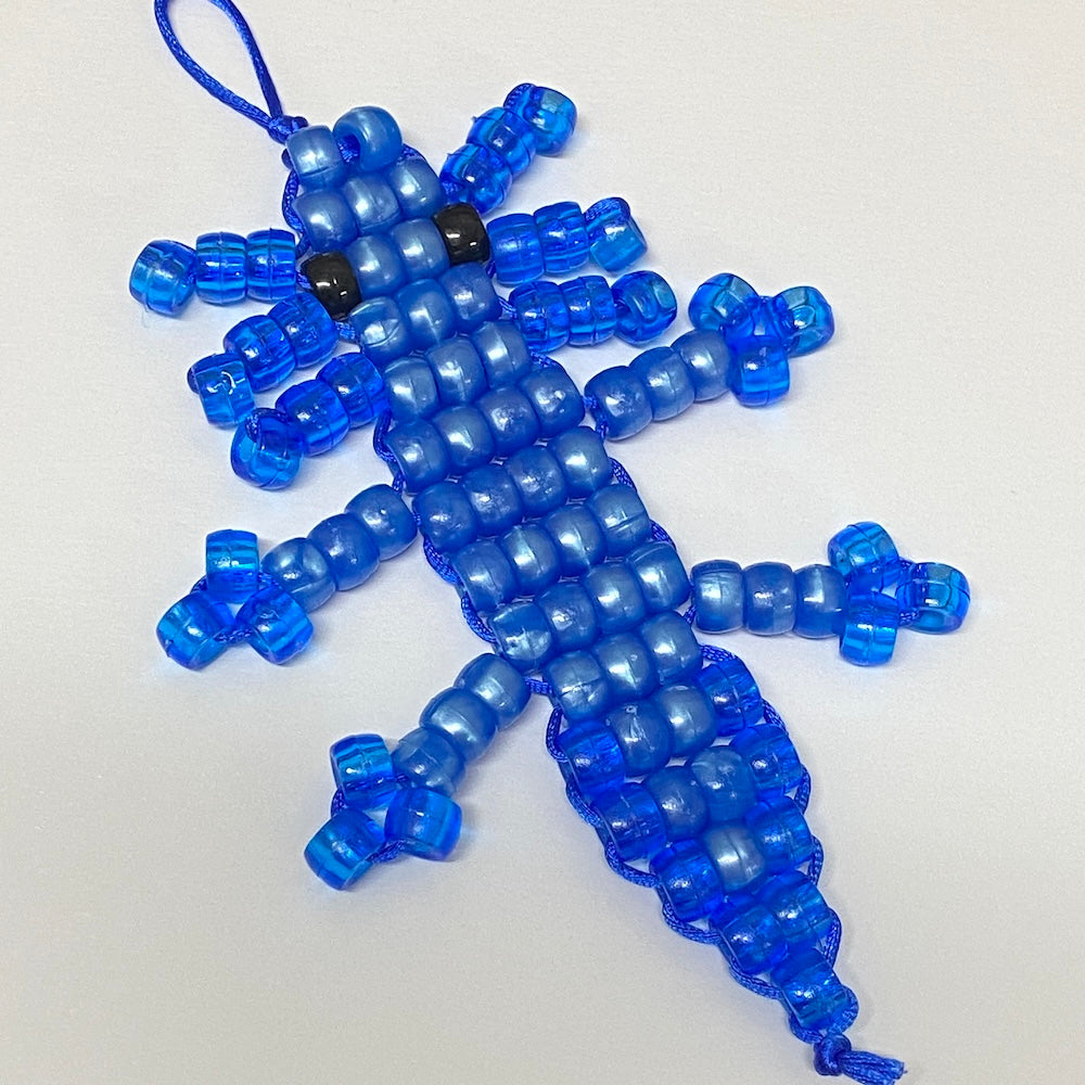Blue beaded axolotl toy on a white background