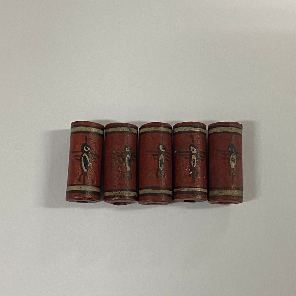 Five cylindrical vintage ceramic beads with birds depicted in black and white on a light gray background