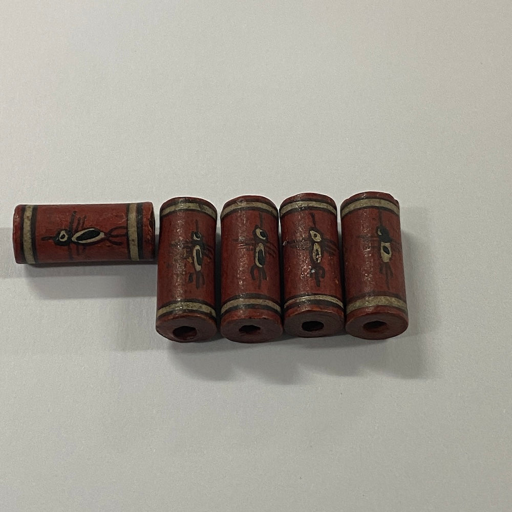 Set of five cylindrical cultural ceramic beads with decorative painting on a white background