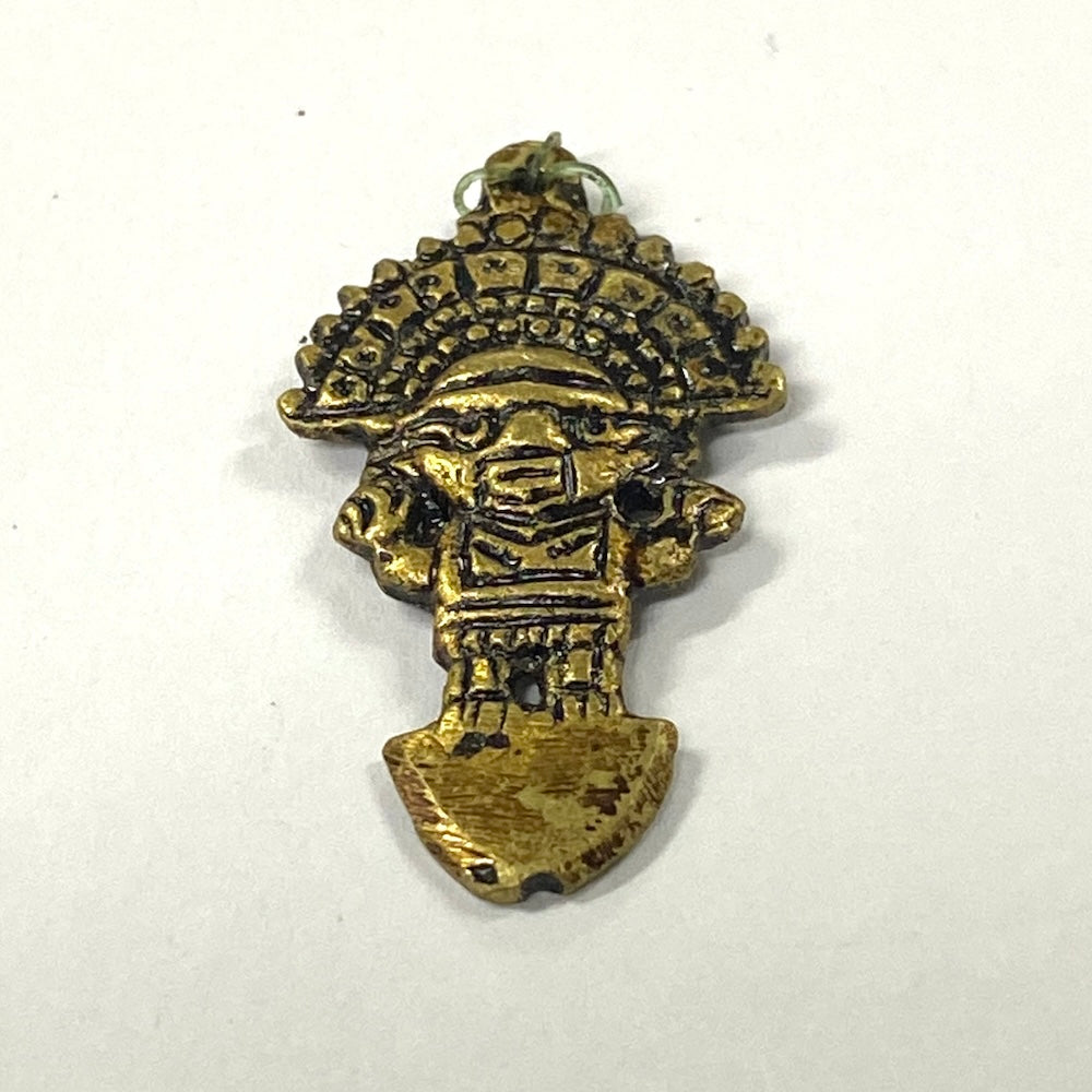 Bronze pendant with intricate Tumi design on a white background