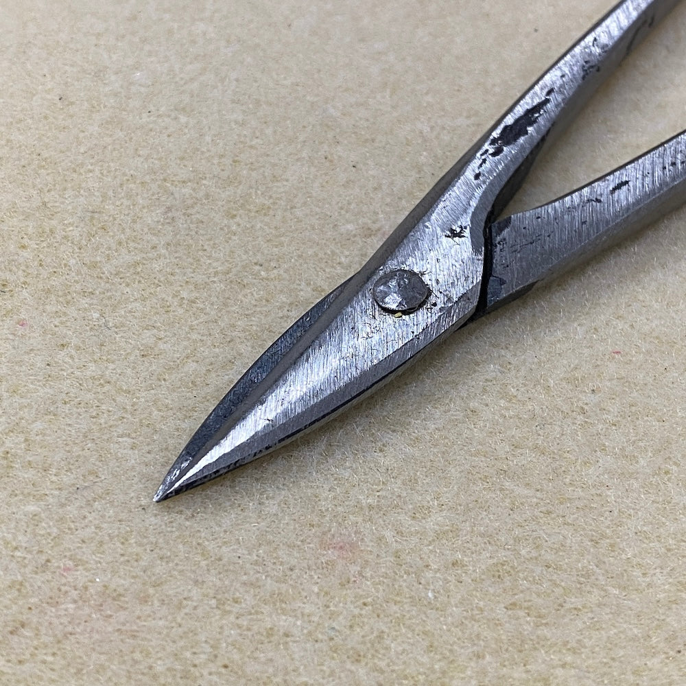 Pair of metal cutter pliers on a beige surface