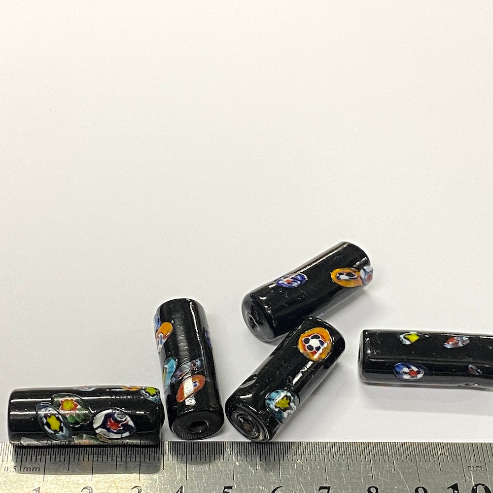 Black cylindrical beads with colorful patterns on a white background