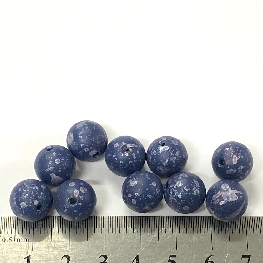Blue speckled beads with a ruler for scale on a white background