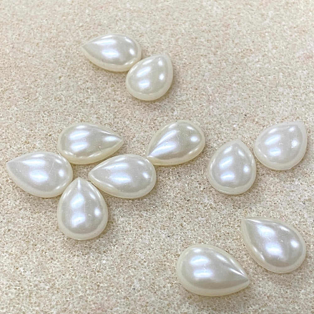 Teardrop-shaped pearls on a beige background