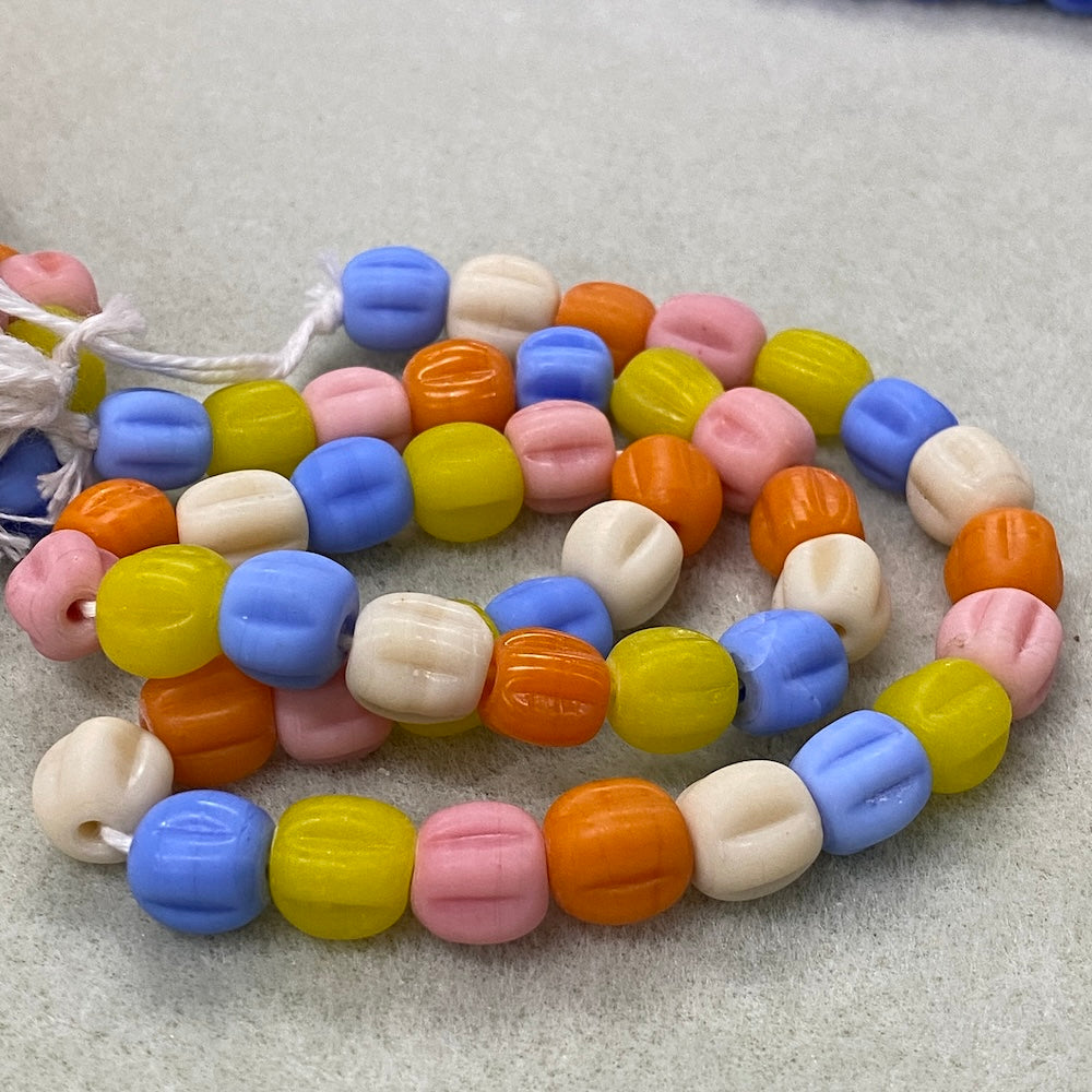 Colorful pastel glass beads on a textured surface