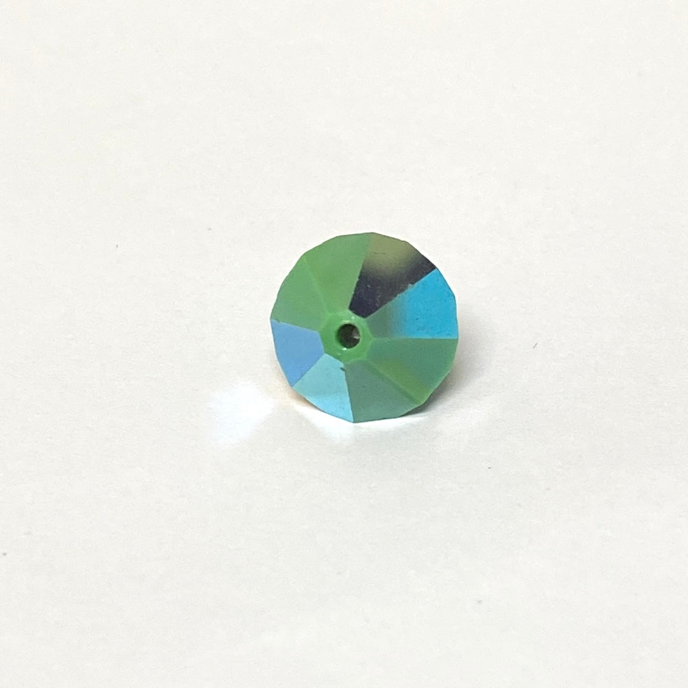 faceted green crystal bead on a white background