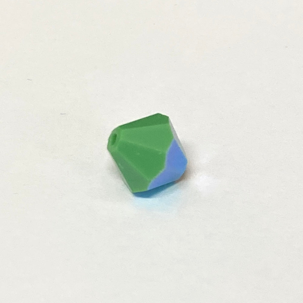 faceted green crystal bead on a white background