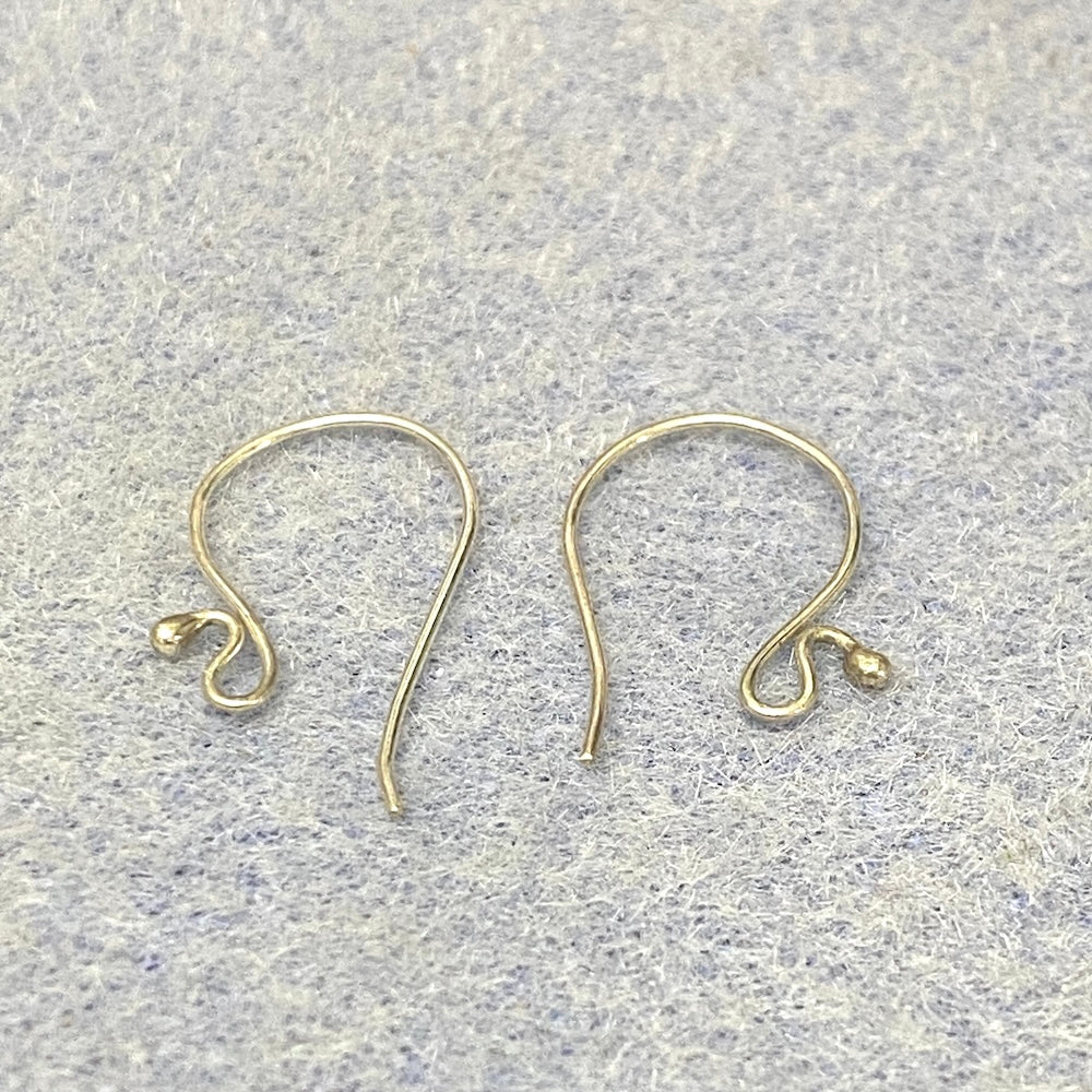 Two sterling silver 925 earring hooks on a textured gray background