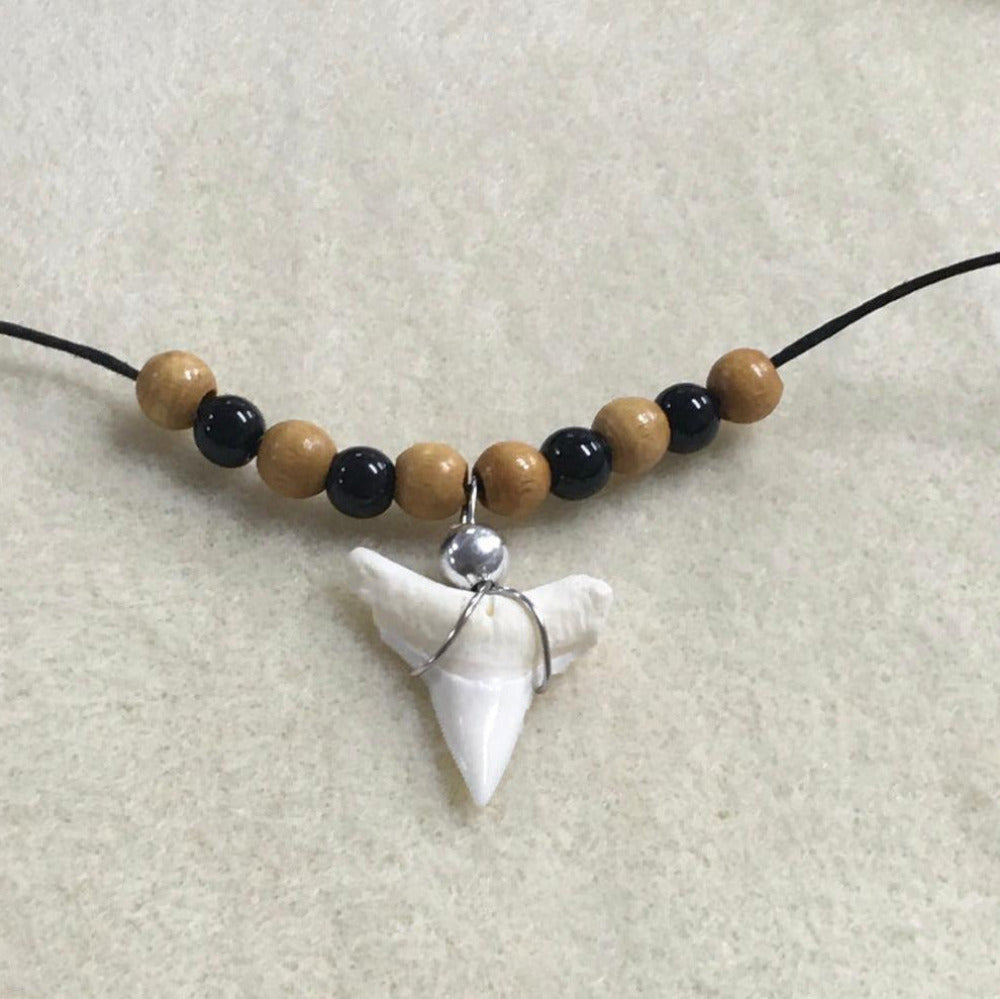 close up photo of the featured sharks tooth on a handmade necklace