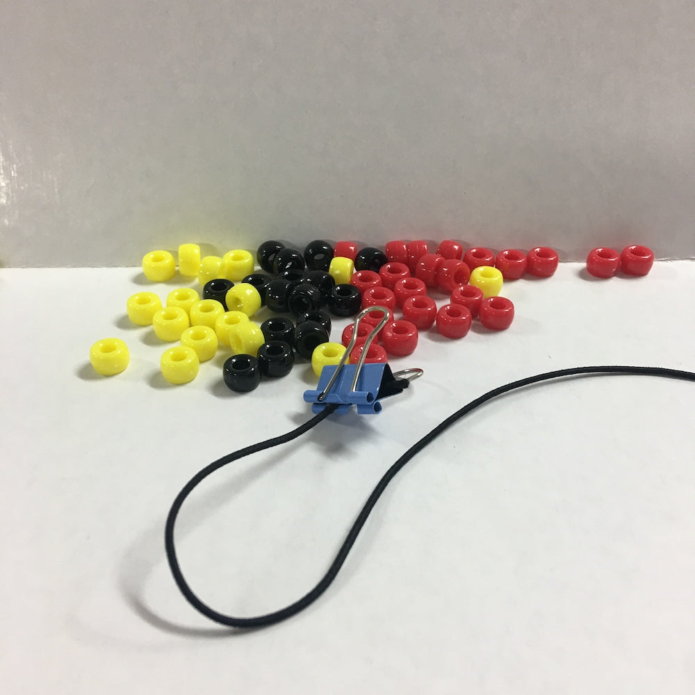 tribal pony beads with an elastic cord and clip on a white and grey background