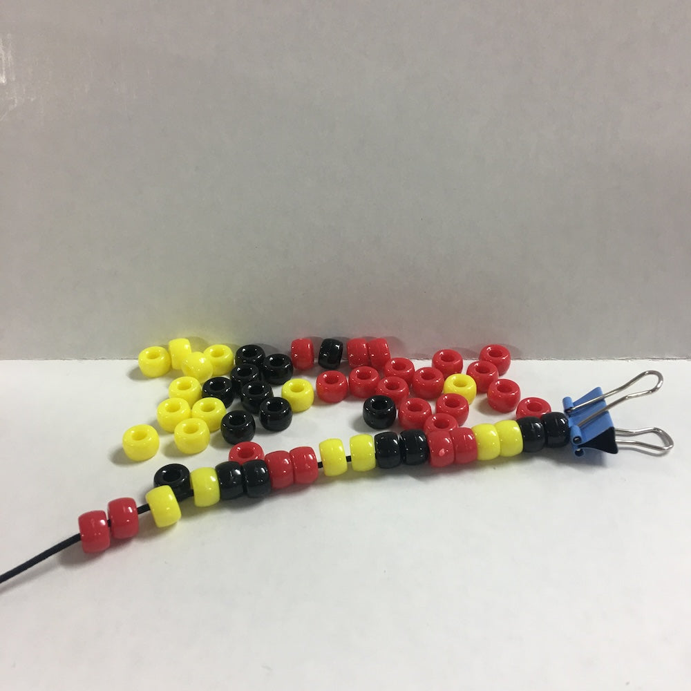 tribal pony beads with an elastic cord and clip on a white and grey background