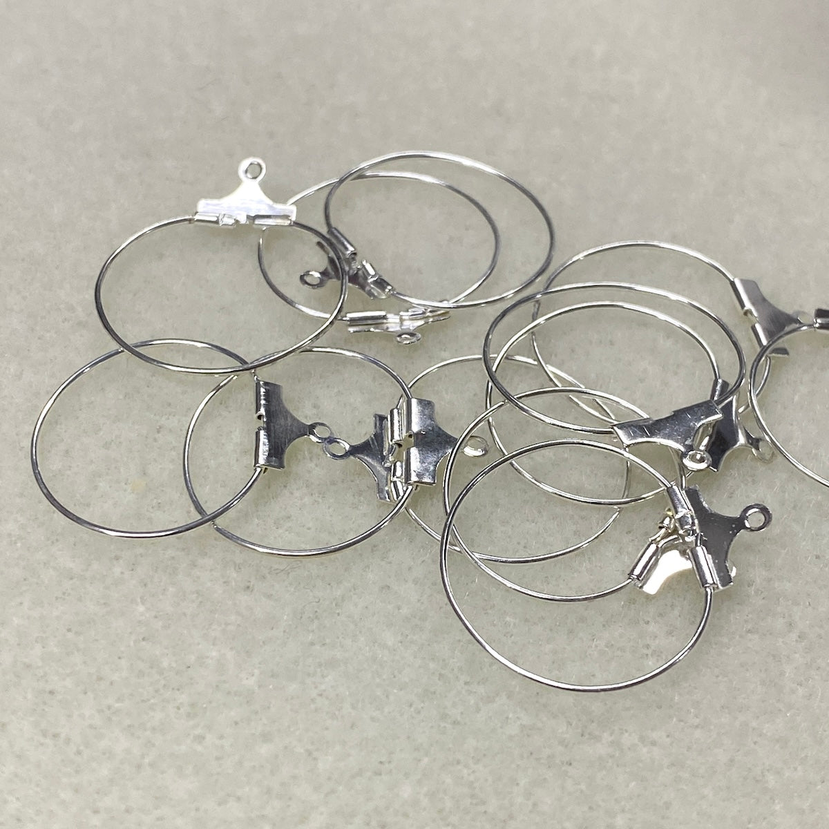 Set of silver hoop earrings on a light gray background